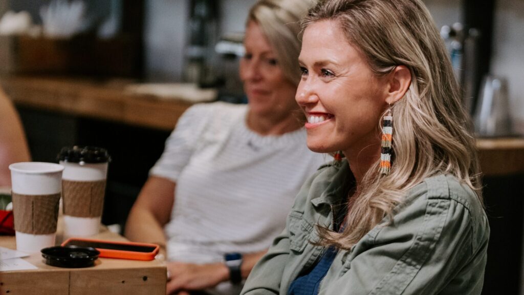 white women sitting and smiling at a scatter joy event in columbus ohi